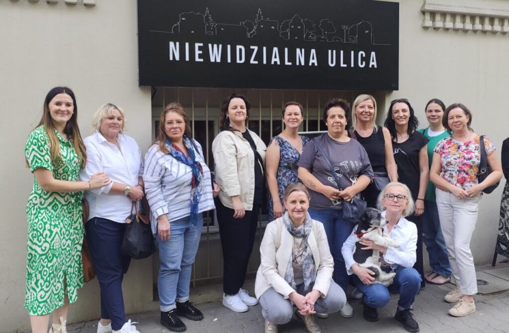 grupa kobiet stoi na tle napisu niewidzialna ulica
